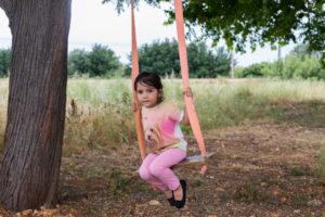 Paseos en familia, la fase más importante Niña en un columpio en el bosque